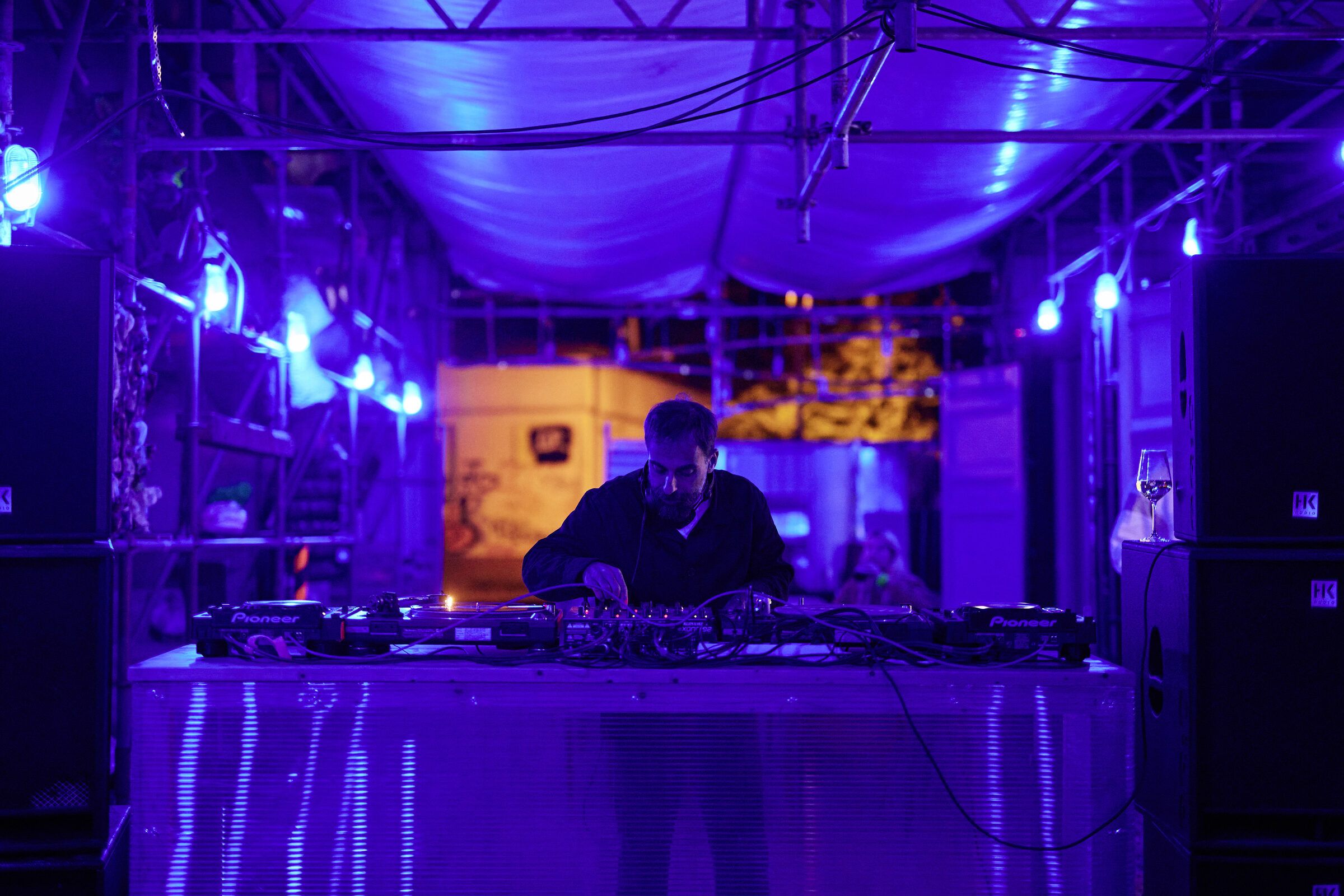 Das DJ-Pult unter der Gerüsthalle ist in blaues Licht getaucht.