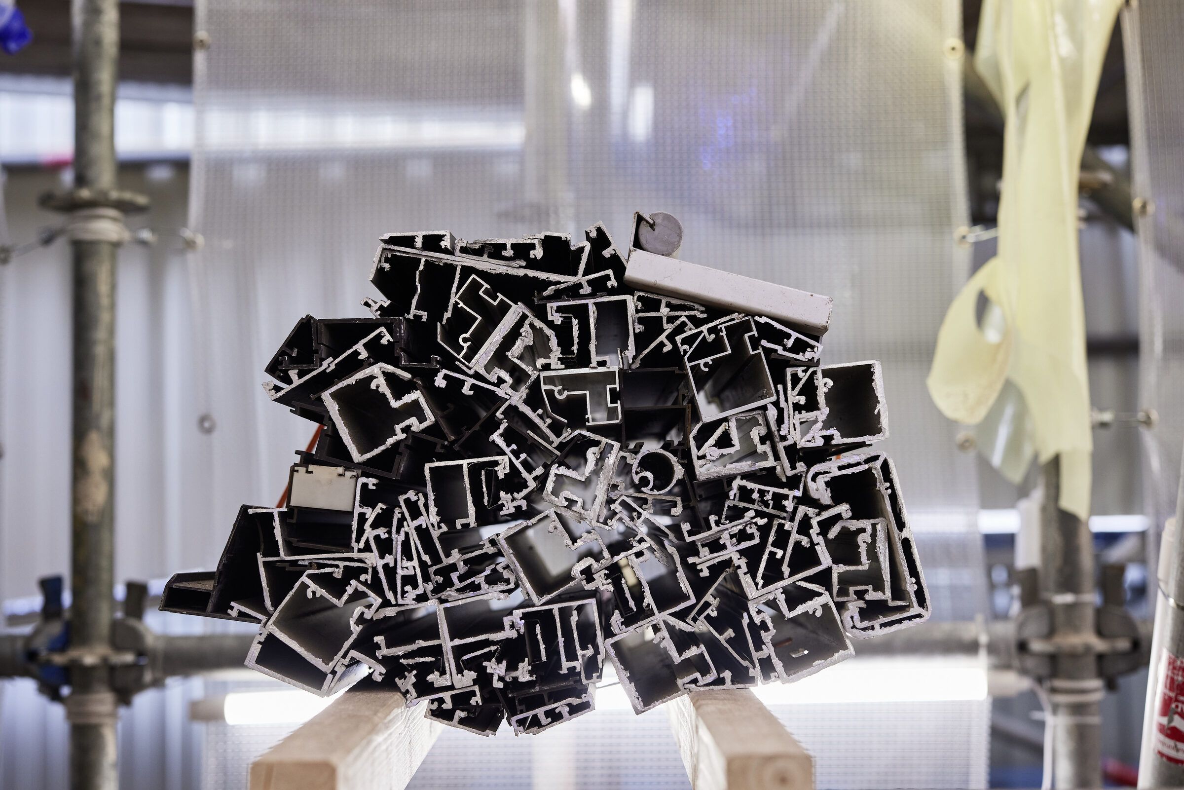 Ein Haufen schwarzer Aluminium-Hohlprofile liegt im Gerüstfach.
